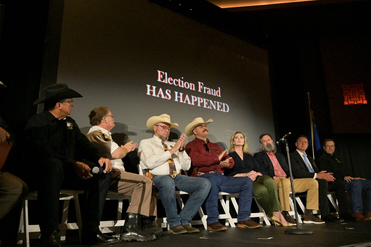 Sheriffs and panelists are seen on stage as the screen reads "election fraud has happened" during an event held by the Constitutional Sheriffs and Peace Officers Association in Las Vegas on July 12, 2022.