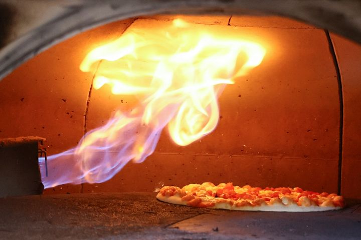 Μια πίτσα ψήνεται σε παραδοσιακό ιταλικό φούρνο πίτσας με φυσικό αέριο, σε ένα εστιατόριο στη Βόννη της Γερμανίας, 11 Οκτωβρίου 2022.REUTERS/Wolfgang Rattay