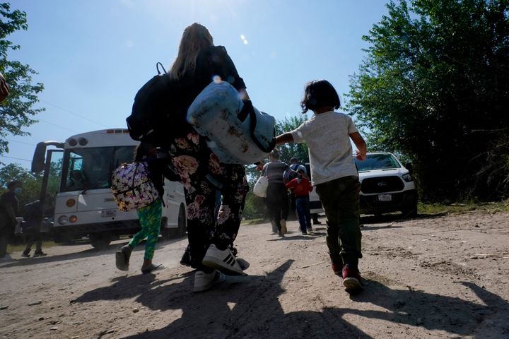 A migrant family from Venezuela walks to a Border Patrol transport vehicle after they and other migrants crossed the U.S.-Mexico border and turned themselves in on June 16, 2021, in Del Rio, Texas.