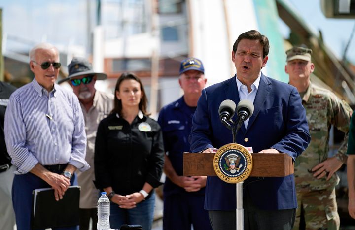 President Joe Biden listens as Florida Gov. Ron DeSantis speaks after they toured an area impacted by Hurricane Ian on Oct. 5 in Fort Myers Beach, Florida.