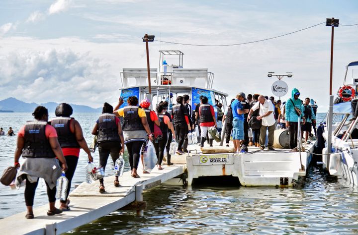 Stranded migrants, mostly from Venezuela, get on a boat in the Colombian port town of Necocli to cross into neighboring Panama to continue their journey to the United States on Oct. 11, 2022.