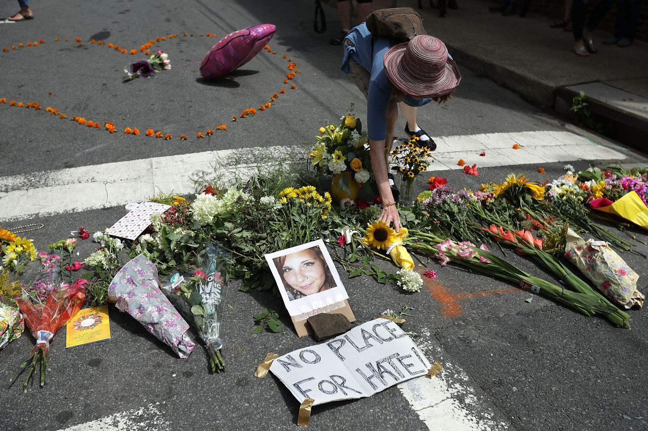 A woman places flowers at an informal memorial to 32-year-old Heather Heyer on Aug. 13, 2017. Heyer was killed when a car plowed into a crowd of people protesting the white supremacist Unite the Right rally, in Charlottesville, Virginia.