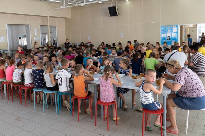 Children from different orphanages from the Donetsk region, eat a meal at a camp in Zolotaya Kosa, the settlement on the Sea of Azov, Rostov region, southwestern Russia, on July 8, 2022. 