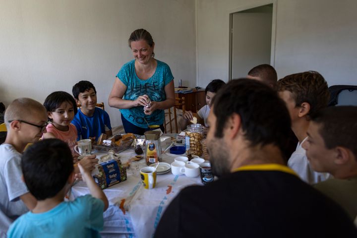 Olga Lopatkina, center, serves her family a snack, in Loue, western France, on July 2, 2022. 