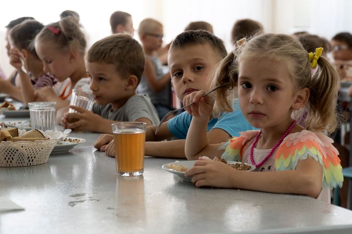 Children from an orphanage in the Donetsk region, eat a meal at a camp in Zolotaya Kosa, the settlement on the Sea of Azov, Rostov region, southwestern Russia, on July 8, 2022. 