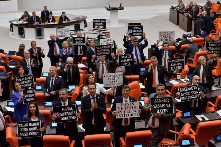 Οι βουλευτές του Ρεπουμπλικανικού Λαϊκού Κόμματος (CHP) της αξιωματικής αντιπολίτευσης κρατούν πλακάτ καθώς διαμαρτύρονται για ένα επίμαχο νομοσχέδιο για τα μέσα ενημέρωσης, που πρότεινε το Κόμμα AKP του Προέδρου Ταγίπ Ερντογάν και οι εθνικιστές σύμμαχοί του, στο τουρκικό κοινοβούλιο στην Άγκυρα, Τουρκία, 4 Οκτωβρίου 2022.
