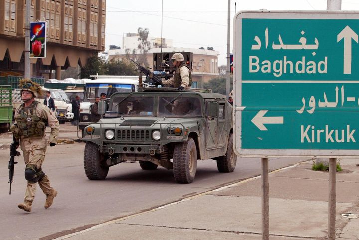 A U.S. soldier from the 4th Infantry Division runs in the street during a patrol in downtown Tikrit, north of Baghdad, on Dec. 16, 2003. The congressional authorization for military action in Iraq, approved in 2002, could soon be ended.