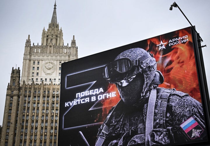 TOPSHOT - Russian Foreign Ministry building is seen behind a social advertisement billboard showing Z letters - a tactical insignia of Russian troops in Ukraine and reading "Victory is being Forged in Fire" in central Moscow on October 13, 2022. - Five Russians drafted to fight in Ukraine, as part of the "partial" mobilization ordered in September, died after joining the army, authorities said, as similar announcements have multiplied in recent days. (Photo by Alexander NEMENOV / AFP) (Photo by ALEXANDER NEMENOV/AFP via Getty Images)