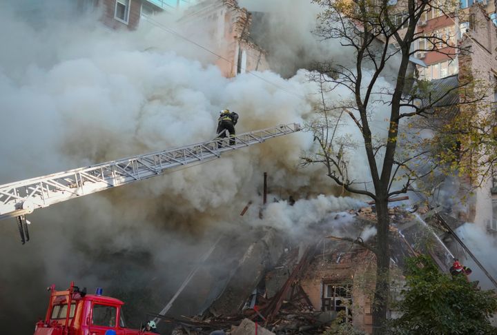 Firefighters work after a drone fired on buildings in Kyiv, Ukraine, on Oct. 17, 2022.