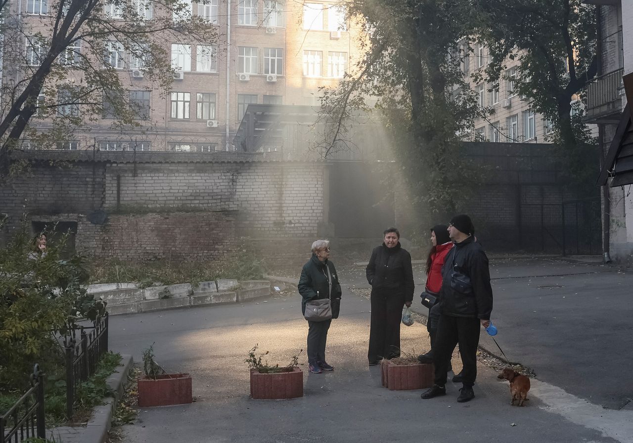 Local residents look on as smoke rises after a Russian drones strike, which local authorities consider to be Iranian made unmanned aerial vehicles (UAVs) Shahed-136, amid Russia's attack on Ukraine, in Kyiv, Ukraine October 17, 2022. 