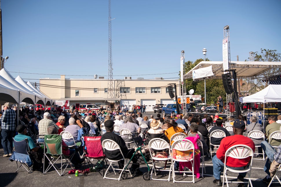 Festivalgoers listen to a rock and roll cover band.