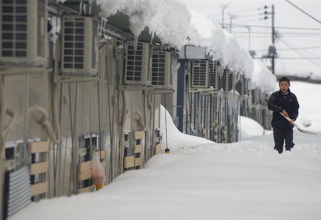 豪雪で、雪に埋もれる新潟地震被災者が暮らす仮設住宅。窓の上まで雪に埋もれている＝2005年2月12日、新潟県小千谷市の元中子仮設住宅