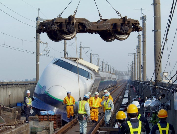 再開された上越新幹線「とき325号」の撤去作業。つり上げられているのは、車両を移し替えるため、上りレールに乗せられる台車＝2004年11月10日、新潟県長岡市の新幹線高架上