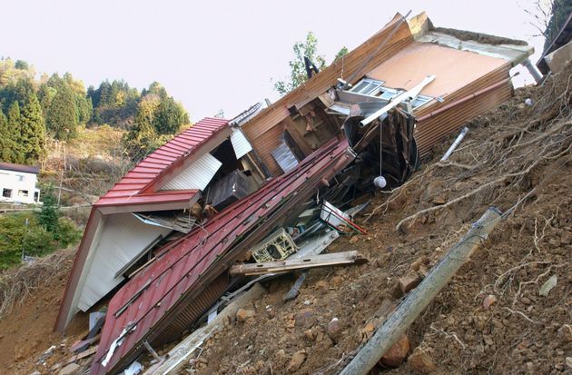 川沿いの土地が崩れて土台ごと崩壊した民家＝2004年11月9日、新潟県栃尾市
