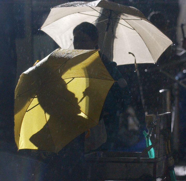 避難所で生活している子供たちは雨の降る中、傘を差しながら歯を磨いた＝2004年10月26日、新潟県小千谷市の小千谷小学校
