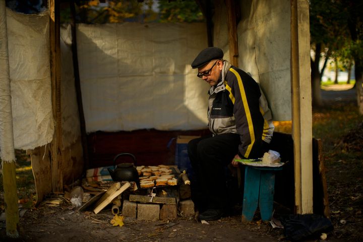 Anton Sevrukov, 47, toasts bread over fire in a makeshift stove in Kivsharivka, Ukraine, on Oct. 16, 2022. 