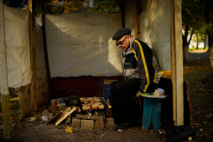 Anton Sevrukov, 47, toasts bread over fire in a makeshift stove in Kivsharivka, Ukraine, on Oct. 16, 2022.
