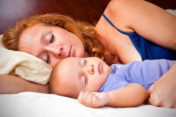 A photograph of a mother sleeping with her baby.Please browse: