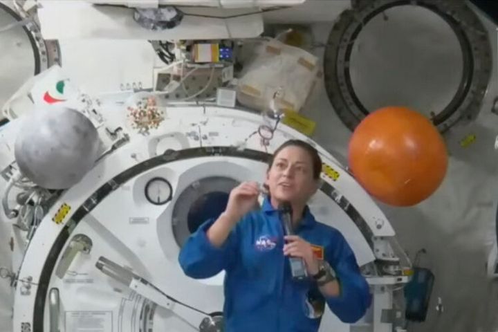 In this image from video made available by NASA, astronaut Nicole Mann shows her dreamcatcher during an interview on Wednesday, Oct. 19, 2022. (NASA via AP)