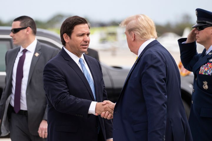 Florida Gov. Ron DeSantis (R) greets then-President Donald Trump as he arrives at the Orlando Sanford International Airport on March 9, 2020, in Florida.