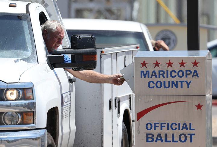 A voter places a ballot in a drop box outside the Maricopa County Elections Department on Aug. 2 in Phoenix.