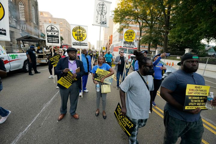 Les résidents et les partisans de Jackson tiennent des pancartes alors qu'ils marchent vers le manoir du gouverneur à Jackson, dans le Mississippi, pour protester contre les problèmes d'eau, la pauvreté et d'autres maux sociaux, à Jackson, dans le Mississippi, dans le cadre de la campagne des pauvres "Lundi moral," 10 octobre 2022. (AP Photo/Rogelio V. Solis)