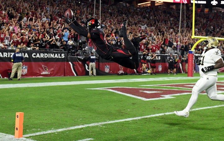 Marco Wilson of the Arizona Cardinals dives into the end zone for a touchdown after intercepting a pass in the game Thursday against the New Orleans Saints in Glendale, Arizona. 