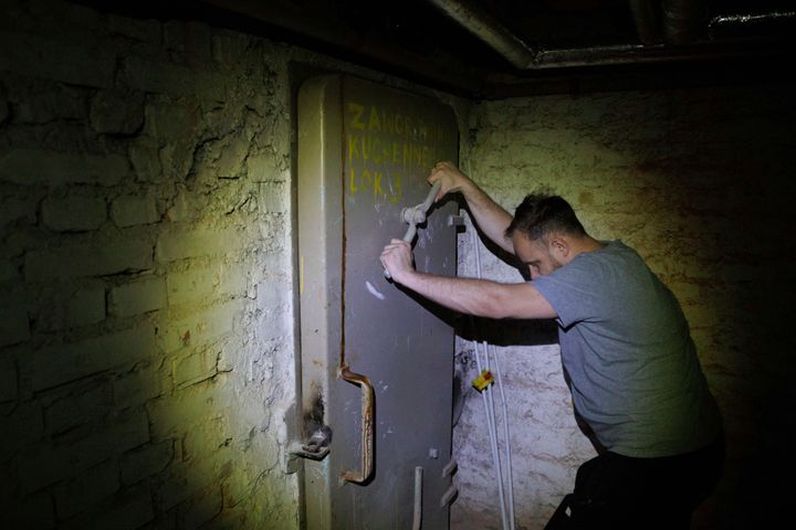 Jacek, 37, a local resident, closes a door to a shelter in the basement of a residential building in Warsaw, Poland, on Oct. 19, 2022. Fighting around Ukraine's nuclear power plants and Russia's threats to use nuclear weapons have reawakened nuclear fears in Europe.