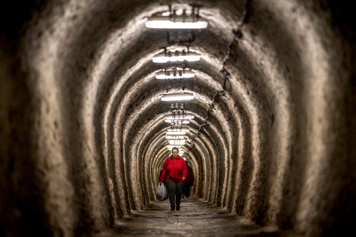 A woman walks inside an access gallery of the Salina Turda, a former salt mine turned touristic attraction, now listed by emergency authorities as a potential civil defense shelter in Turda, central Romania, on Oct. 17, 2022.