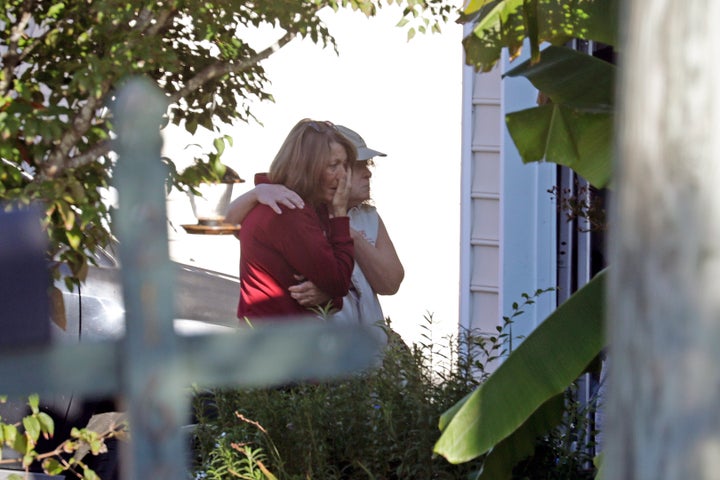 Neighbors embrace as police remain on the scene at Castle Pines Drive and Sahalee Way following a Thursday night shooting in Raleigh, N.C., on Friday, Oct. 14, 2022.