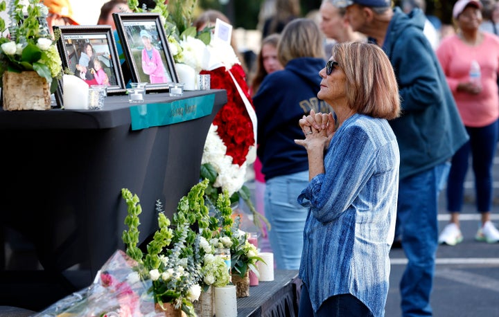 A woman stands before a photo of Raleigh shooting victim Susan Karnatz at a makeshift memorial at the Hedingham neighborhood.