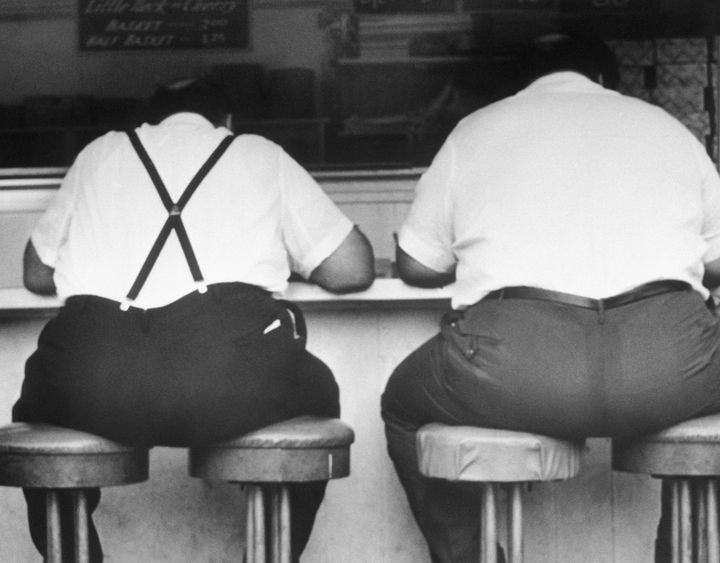 Two obese men sit at the counter in a diner in Atlantic City, taking up two stools apiece.