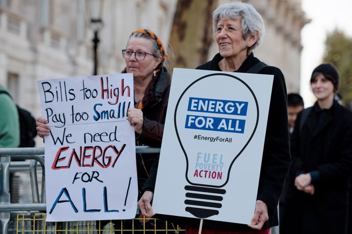 Protesters against rising energy prices hold placards outside Downing Street on October 19, 2022