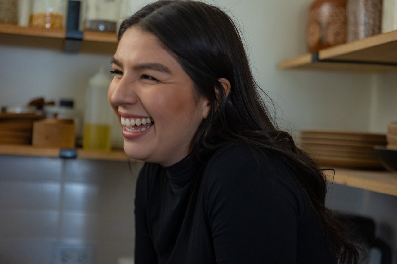 Alma Blancarte-Mora sits on the counter of her home as her husband Cristóbal Mora makes coffee before they start working from home in Little Village.