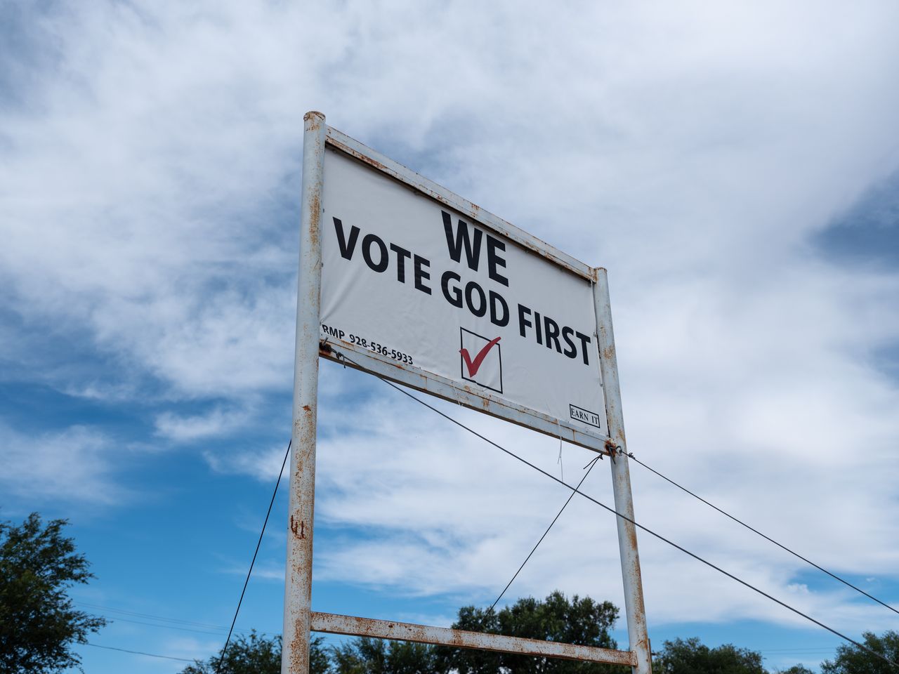 A sign declaring “We Vote God First” sits along a roadside in Snowflake, Arizona.