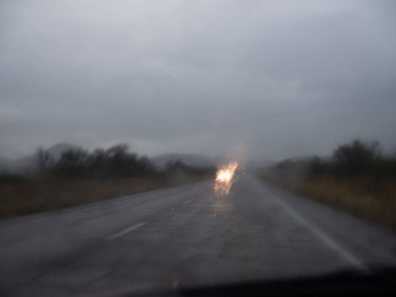 Approaching headlights blur in the rainfall between Bisbee and Tombstone.