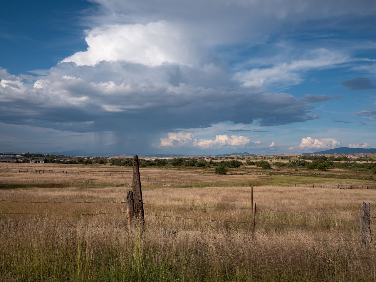 A roadside view with a distant rainstorm outside Prescott, Arizona.