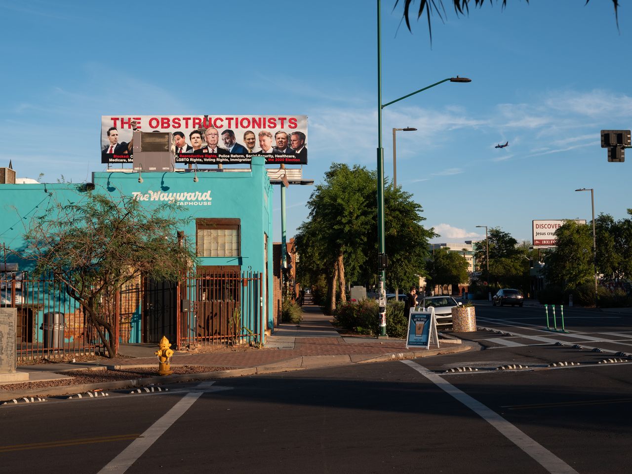 A billboard depicting radical conservative members of Congress as “The Obstructionists” towers over a street in Phoenix.