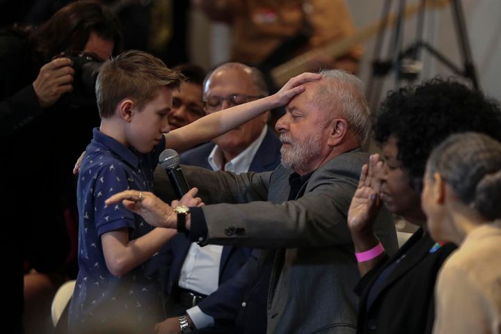 Luiz Inácio Lula da Silva mientras recibe una oración de David Mikami, de 9 años de edad, en Sao Paulo