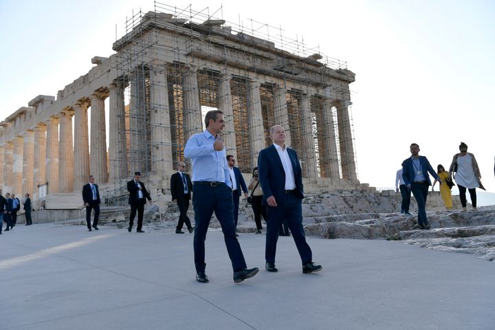 Greek Prime Minister Kyriakos Mitsotakis, left, and German Chancellor Olaf Scholz talk each other as they walk in front of the ancient Parthenon Temple at the Acropolis hill during a visit, in Athens, Thursday, Oct. 27, 2022. Scholz is in Athens on a two-day official visit. (AP Photo/Michael Varaklas)