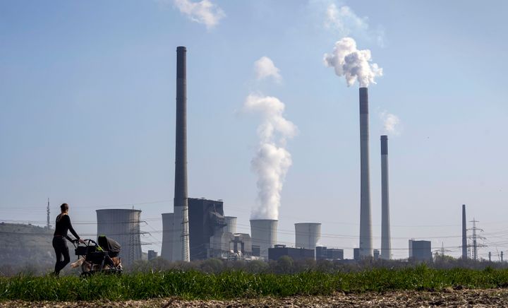A mother pushes a stroller in front of the Scholven coal-fired power station, owned by Uniper, in Gelsenkirchen, Germany, March 28, 2022. The world remains “far behind” and is not doing nearly enough to reach any of the global goals limiting future warming, a United Nations report said. (AP Photo/Martin Meissner, File)