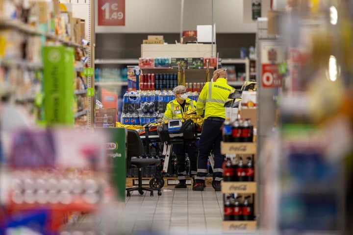 Emergency personnel attend to a scene of an attack in Milan, Italy, Thursday Oct. 27, 2022. A man armed with a knife stabbed five people inside a shopping center south of Milan on Thursday. (LaPresse via AP)