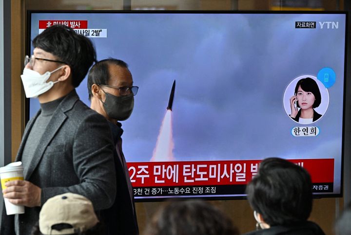 People watch a television screen showing a news broadcast with file footage of a North Korean missile test, at a railway station in Seoul on Oct. 28, 2022, after North Korea fired two short-range ballistic missiles according to South Korea's military. 