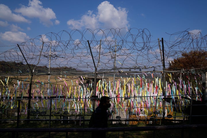 A visitor walks near the wire fences decorated with ribbons with messages wishing for the reunification of the two Koreas at the Imjingak Pavilion in Paju, South Korea, on Oct. 28, 2022. 