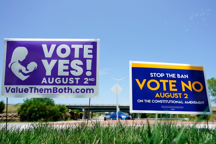 Des pancartes indiquant aux parties adverses lors du vote du 2 août au Kansas sur l'opportunité de restreindre les droits à l'avortement ont été affichées à l'extérieur de l'autoroute Kansas 10 à Lenexa, Kansas.