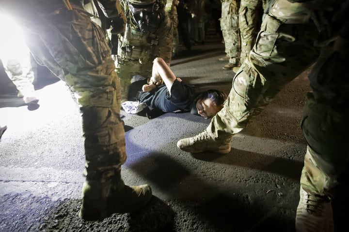 FILE - Federal agents arrest a demonstrator during a Black Lives Matter protest in Portland, Ore., on July 29, 2020. U.S. Department of Homeland Security officials under then-President Donald Trump sought to compile intelligence dossiers on everyone attending Black Lives Matter protests, according to a newly unredacted report. Sen. Ron Wyden, D-Oregon, who obtained the report, said in an email to reporters that surveillance of Portland protesters in 2020 "included lists of friends, family and social media associates for people who posed no threat to homeland security." (AP Photo/Marcio Jose Sanchez, File)