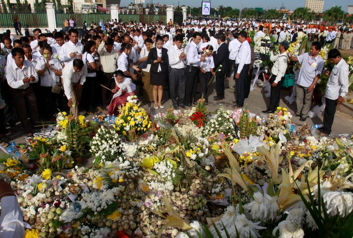 Συγγενείς προσεύχονται για τα θύματα καθώς τοποθετούνται λουλούδια κοντά στην τοποθεσία όπου εκατοντάδες άνθρωποι ποδοπατήθηκαν κατά τη διάρκεια ενός φεστιβάλ νερού στην Πνομ Πενχ της Καμπότζης, Κυριακή, 28 Νοεμβρίου 2010. (AP Photo / Heng Sinith)