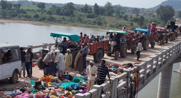 Ινδοί χωρικοί με τρακτέρ περνούν δίπλα από τα νεκρά θύματα μιας γέφυρας στον ποταμό Sindh στην περιοχή Datia στην πολιτεία Madhya Pradesh, Ινδία, Κυριακή, 13 Οκτωβρίου 2013. Τουλάχιστον 64 άνθρωποι σκοτώθηκαν την Κυριακή σε ποδοπάτημα Ινδουιστών πιστών που διέσχισαν τη γέφυρα προς τον απομακρυσμένο ναό του χωριού Ratangarh για να τιμήσουν την ινδουιστική μητέρα θεά Durga την τελευταία ημέρα του δημοφιλούς 10ήμερου φεστιβάλ Navaratra. Το χάος ξέσπασε καθώς κυκλοφόρησαν φήμες ότι η γέφυρα κατέρρεε, σύμφωνα με τον Δ.Κ. Arya, αναπληρωτή γενικό επιθεωρητή της αστυνομίας στην περιοχή