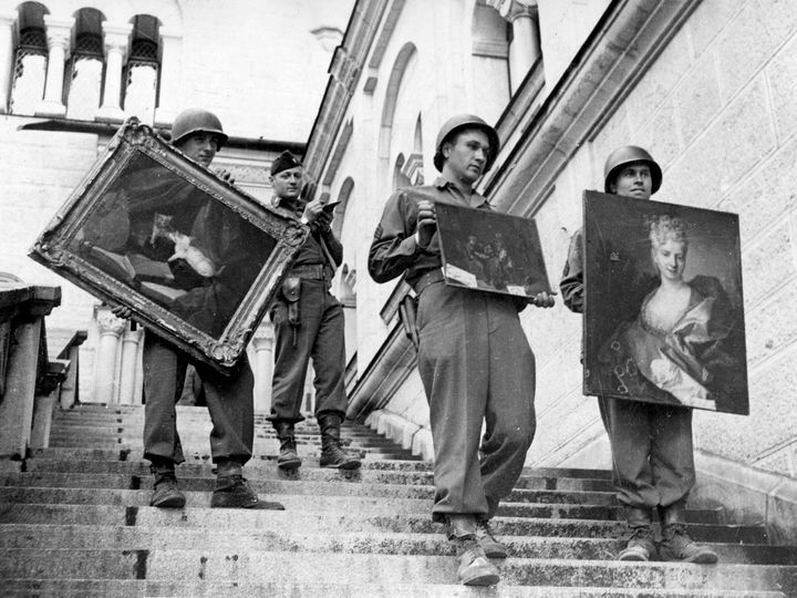 Αμερικάνοι του 7ου Στρατού βρήκαν μια ανεκτίμητη συλλογή από λεηλατημένους θησαυρούς τέχνης κρυμμένα στο Κάστρο Neuschwantstein στο Fussen κοντά στα ελβετικά σύνορα στην Αυστρία, Μάιος 1945. Πίνακες, κοσμήματα, κ.λπ. αξίας δισεκατομμυρίων λιρών είχαν κλαπεί από τους Ναζί από ιδιωτικές συλλογές σε όλη την Ευρώπη. Από αριστερά, οι στρατιώτες εκθέτουν πίνακες ζωγραφικής, "Cat and Mirror" του Jean-Baptiste-Simeon Chardin, 1749. «Χωρικοί που παίζουν χαρτιά σε μια ταβέρνα», του Adriaen Brouwer, 1635; και ένα αγνώστου ταυτότητας πορτρέτο με την ένδειξη «Συλλογή Rothschild 16ος αιώνας».