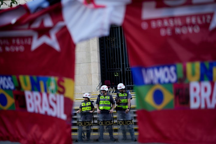 Police stand guarding a street after the closing of the polls for a presidential run-off election in Sao Pablo, Brazil, Sunday, Oct. 30, 2022.